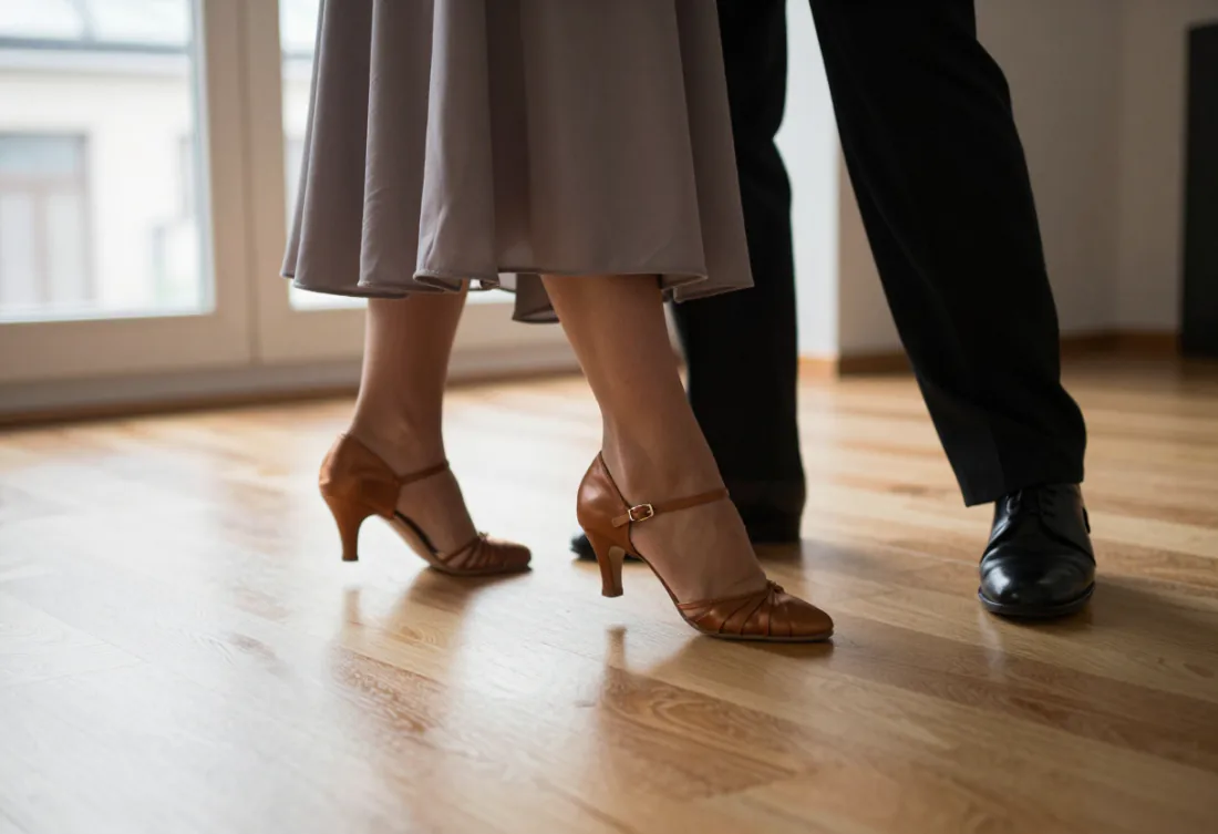 Deux paires de pieds sur le parquet, dressées sur la pointe au milieu d’un pas de valse